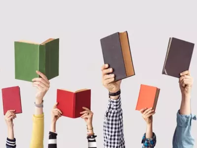 Multiple hands holding up books, forming a row.