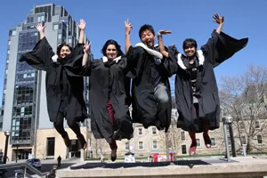 U of T grads in ceremonial robes jumping into the air
