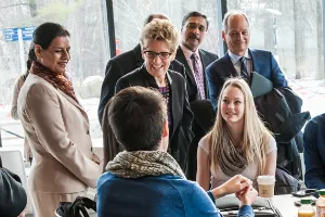 Premier Wynne greets students sitting at a table