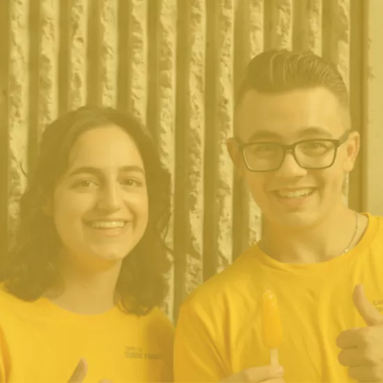 two students smiling in yellow