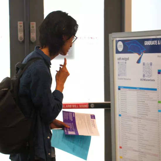 Student reading through list of Graduate and Professional Schools while attending the GPSF Fair 2024