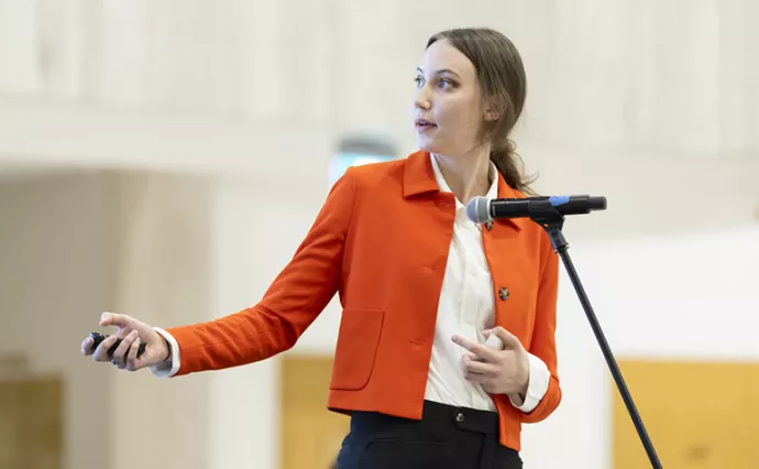 Woman wearing orange jumper presenting slides