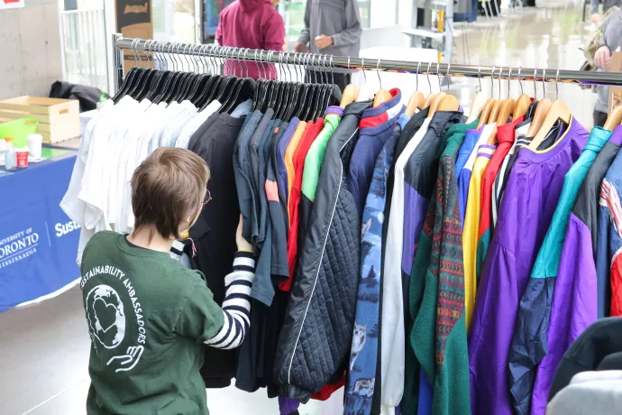 student looking at a rack of clothing
