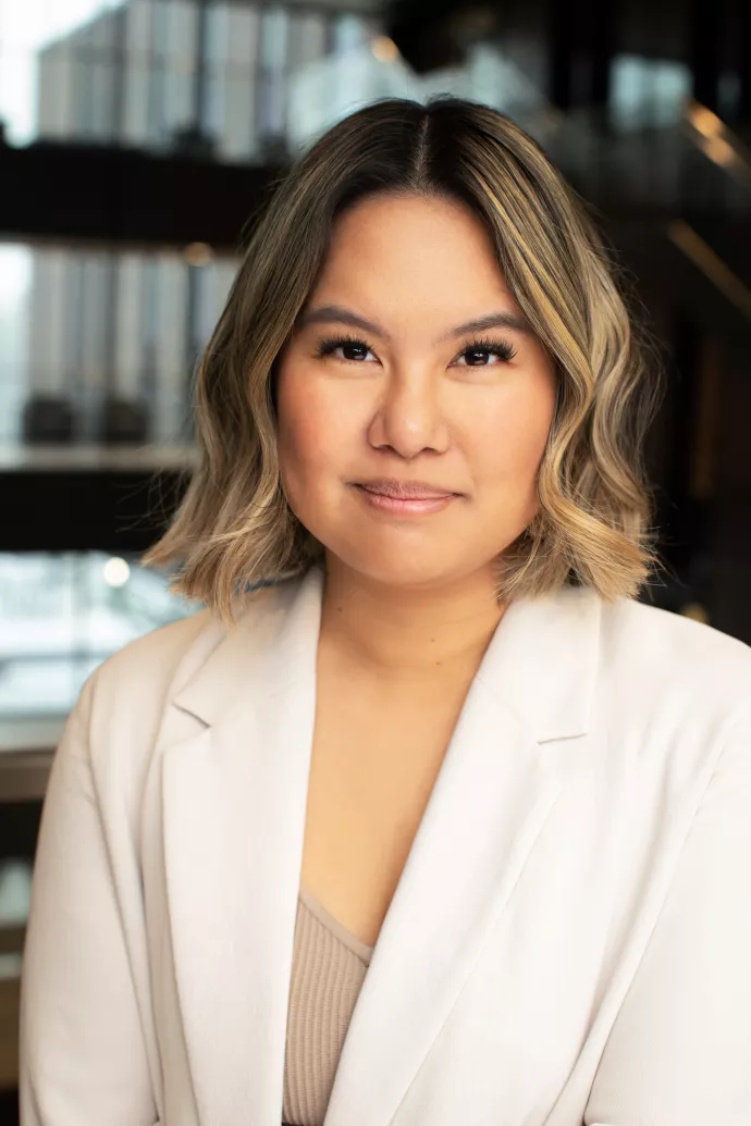 Woman with short hair, wearing a cream-coloured blazer.