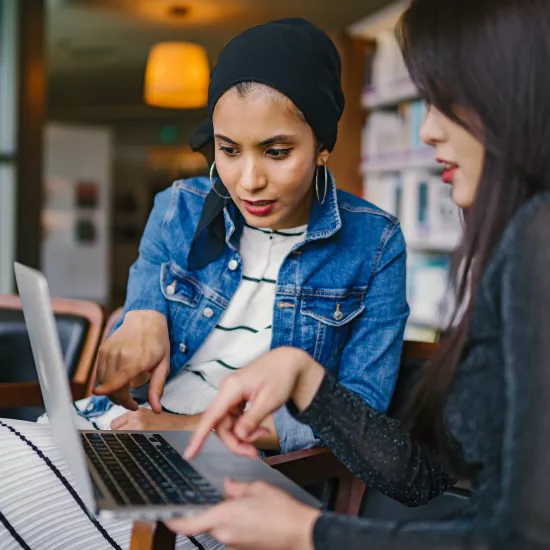 two girls looking at a laptop