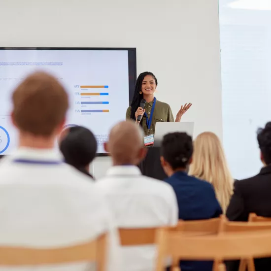 Person doing a presentation in front of an audience, in the perspective of the audience