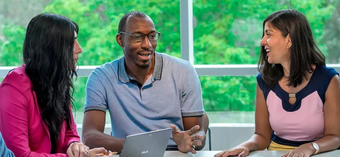 UTM staff talking while seated at a table