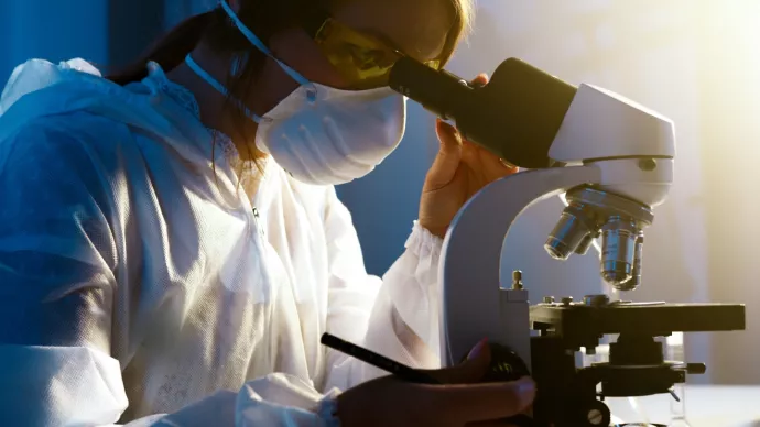 Researcher using microscope