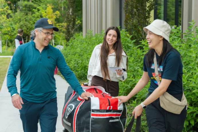 father and daughter smile at move-in day volunteer