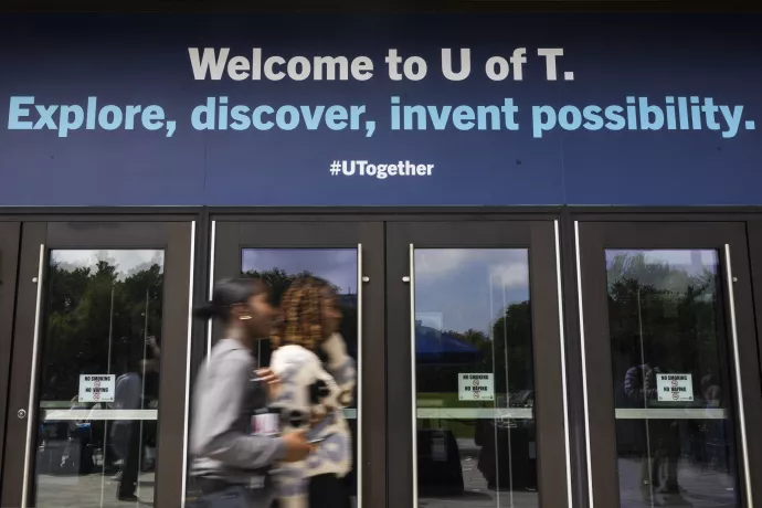 students walk past welcome sign