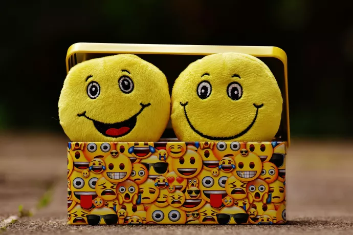 Two emoji pillow in a box decorated with smiley faces