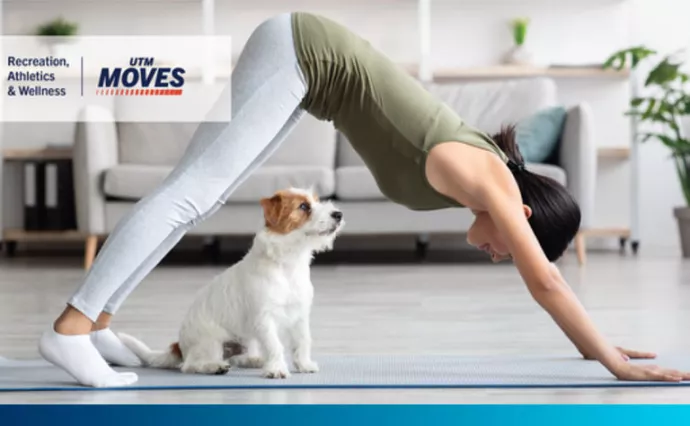 Person doing yoga while a cute puppy sits nearby