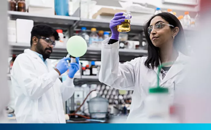 Two scientists work with equipment in a lab