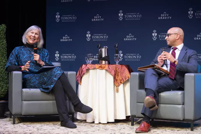 Retired BC judge Marion Buller sits on a chair to the left of a round table and Prof. Randy Boyagoda sits on a chair to the left, facing toward Buller during a discussion on a stage