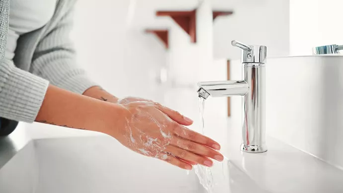 Woman washing her hands at a sink.