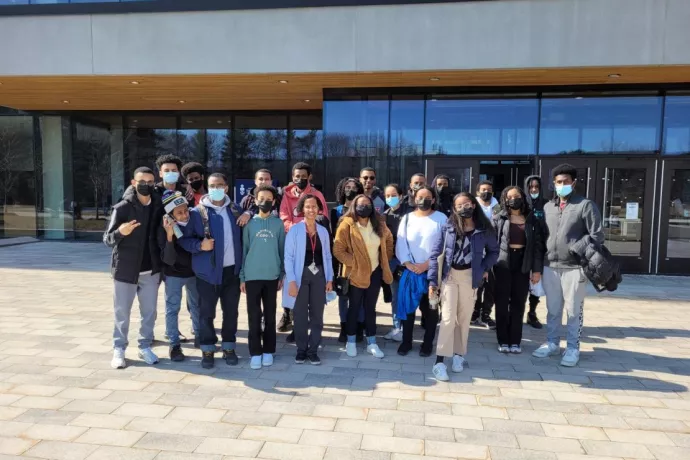 Group photo of Mulu Geletu Heye and local high school students outside a UTM building.