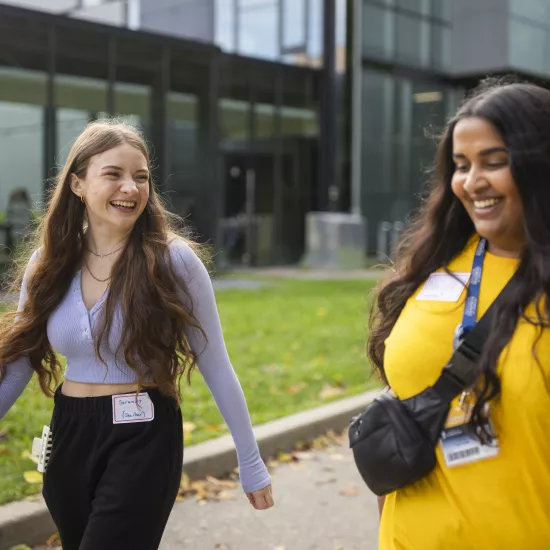 Student speaks with staffer during a walk outside