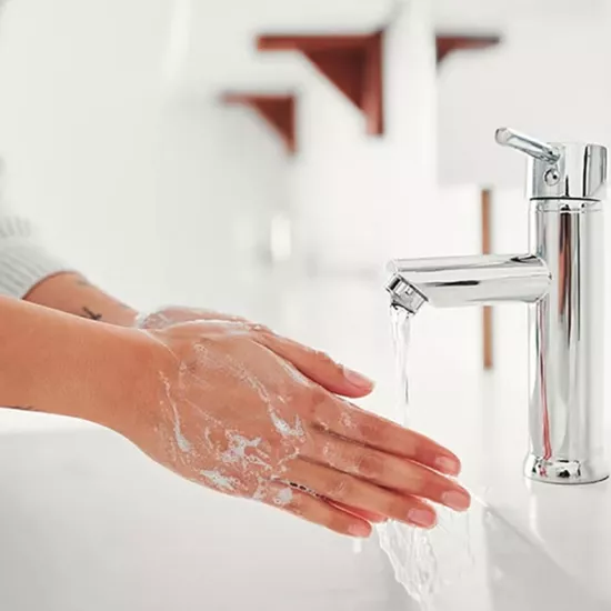 Woman washing her hands at a sink.